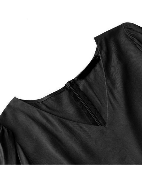 Close-up of black vintage swing dress showing V-neckline and puff sleeves detail